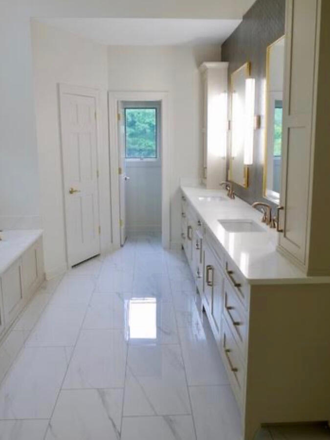One of the most defining design moments is the tobacco fray herringbone tiled feature wall behind the gorgeous gold mirrors and three perfectly scaled sconces with adjustable lighting — adding warmth, depth, and sophisticated contrast to the overall palett